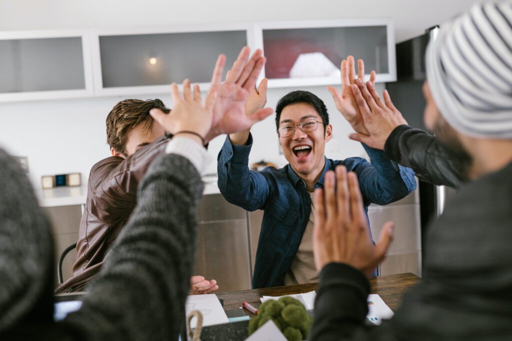 groep mensen geven elkaar high-five aan tafel