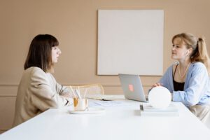 twee vrouwen aan tafel met laptop